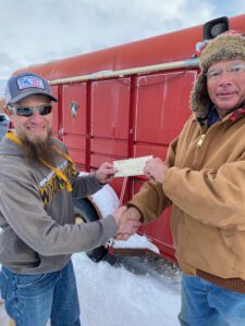Kemmerer Lions Club President Mark Ristau (right) presents the overall big fish of the fishing derby award of $1,000.00 to Jeremiah Johnson of Green River for his 21 1/2 inch Rainbow trout.