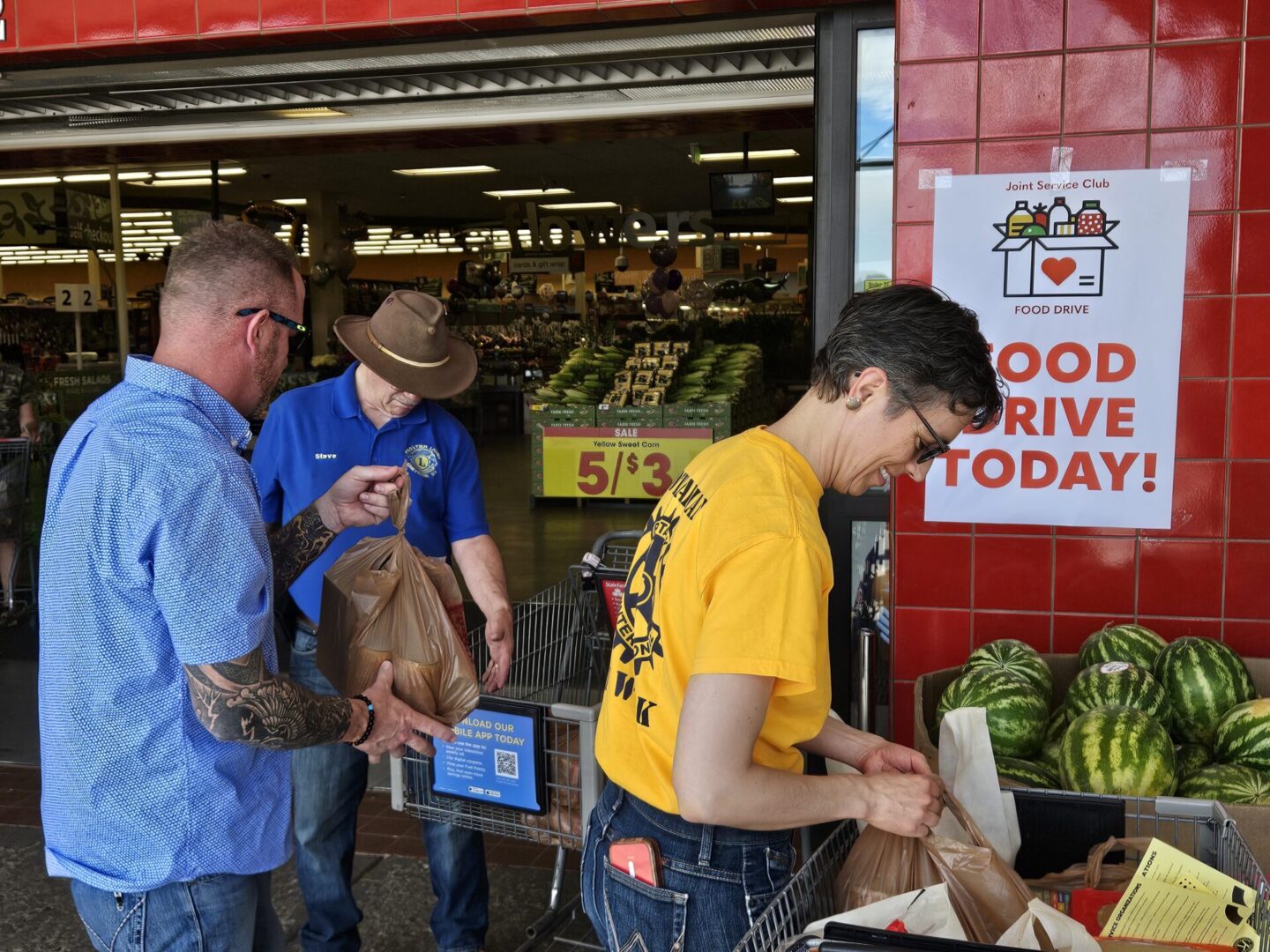 Volunteers from Lions, Rotary and Veterans Rock, load donated food.